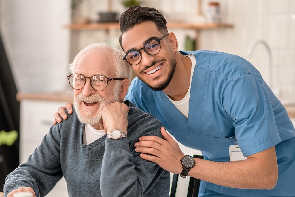 male CNA helping an elderly patient, who took part in cna jobs in Dekalb IL