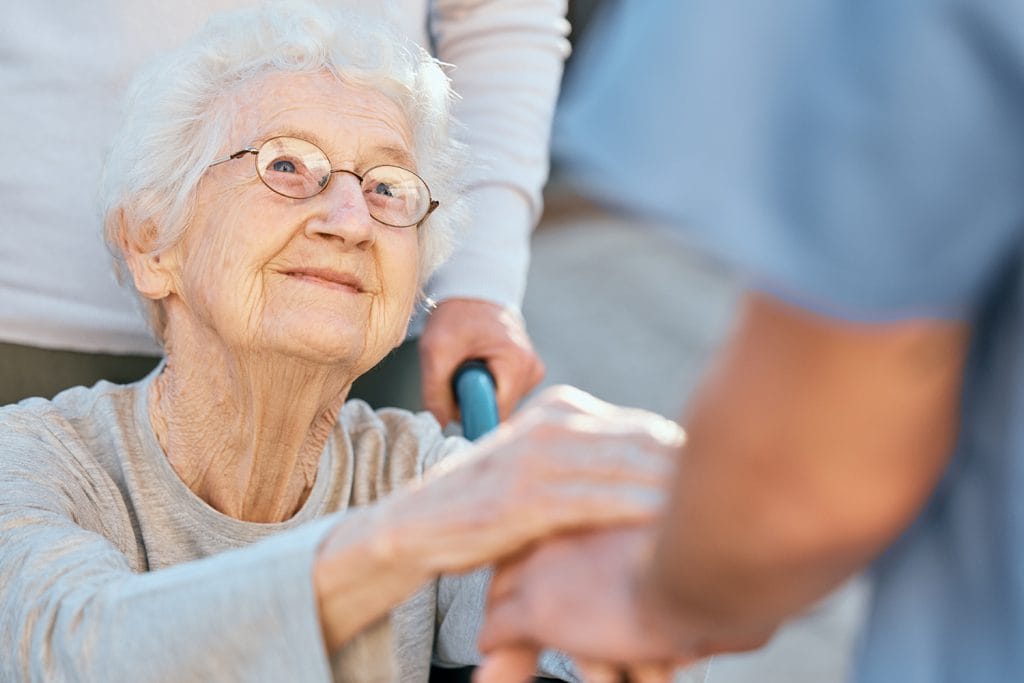 Image of a kind elderly woman looking at a CNA