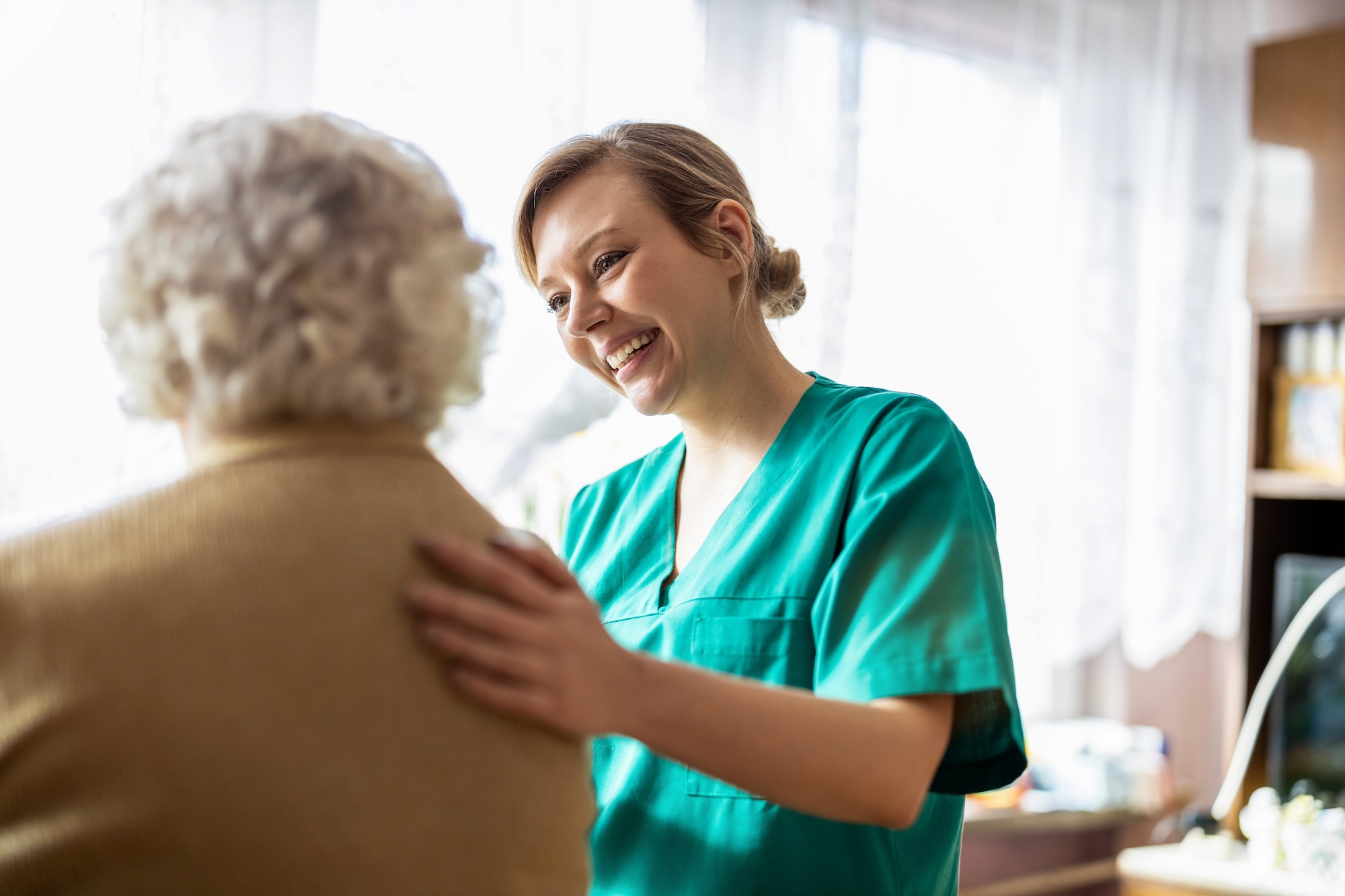 Oak Crest Nurse smiling at a resident she is assisting in the personal care apartments.